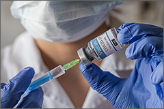 Medical professional holding a syringe and vaccine bottle