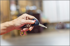 Senior man holding car keys, blurry background